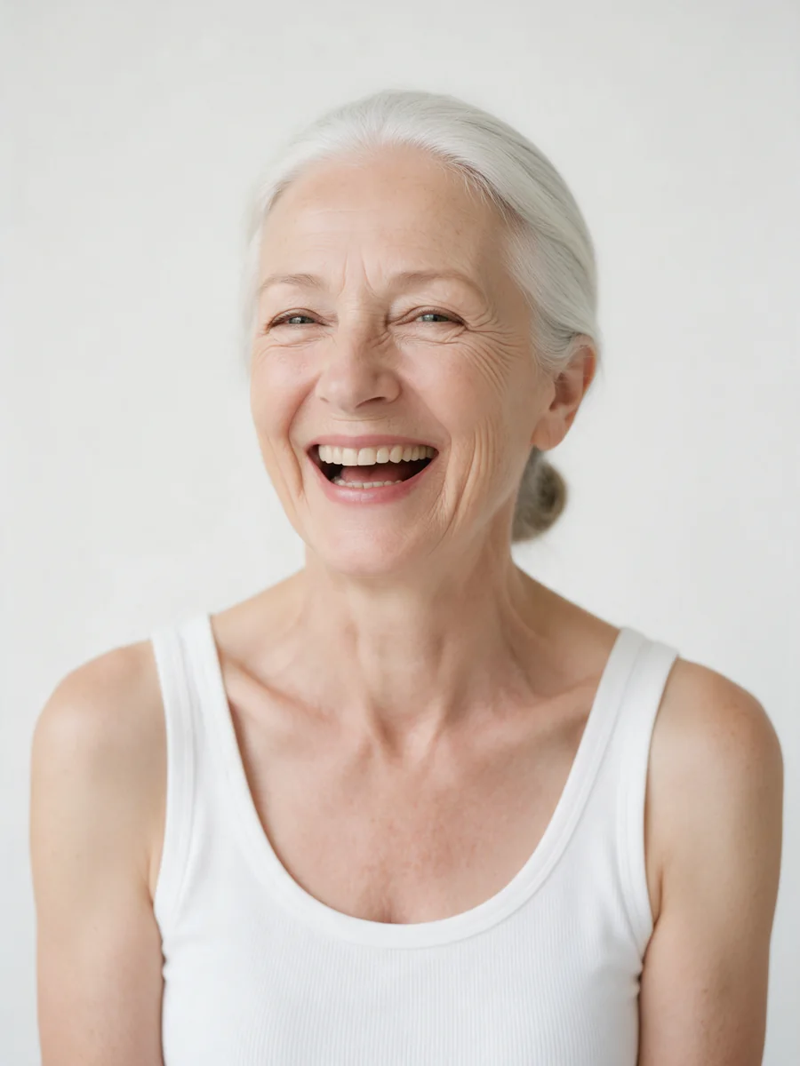 A silver-haired woman in a white tank top, laughing
